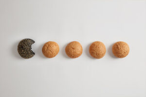 round small organic burger buns without yeast with sesame white surface gluten free healthy product one black is bitten fast food concept bakery nutrition appetizing brioches